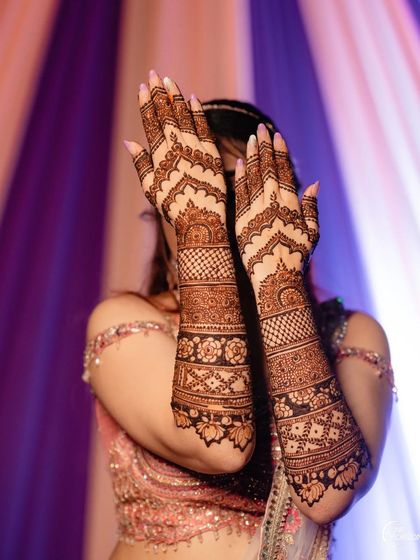 This design features beautiful arched patterns on the back of the hand, combined with intricate bands of geometric and floral work on the arms.