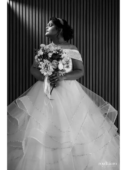 The same bridal portrait, presented in black and white. This version emphasizes the play of light and shadow, the texture of the dress, and the bride's peaceful expression, giving it a timeless quality.