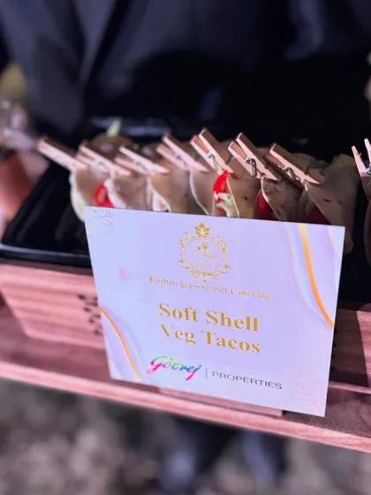 Soft Shell Veg Tacos served on a custom wooden tray for a Godrej Properties event. Each taco is held with a mini clothespin for a playful and practical touch.