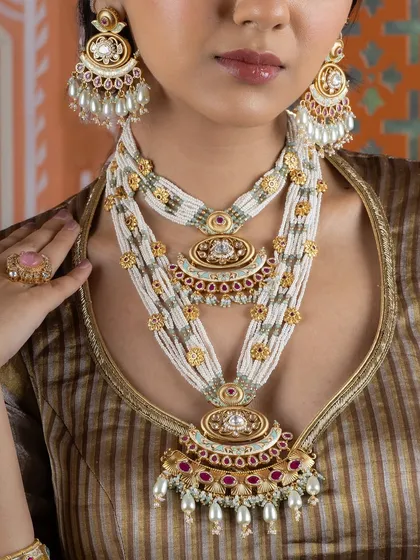A close-up of our layered Kundan pearl necklace. The intricate pendants and the delicate arrangement of pearls and stones showcase the grandeur of traditional Indian jewellery.