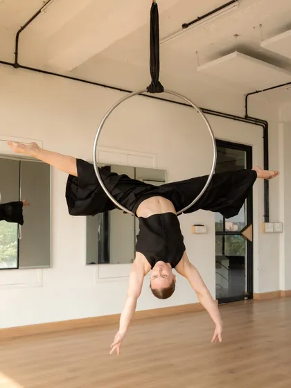 Finding stillness in a middle split on the lyra. This pose is a testament to consistent practice in hip opening and active flexibility, allowing the body to feel secure even when inverted.