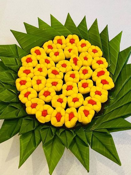 A beautiful arrangement of peda (milk-based sweet) on a plate made of folded banana leaves. This is a creative and traditional way to present sweets at your event.