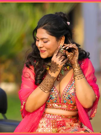 A close-up of the bride adjusting her earring, showing off her intricate henna design. These detailed shots are a must-have.