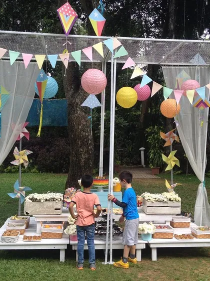 The dessert station for a picnic-themed birthday, set under a canopy decorated with kites and pinwheels. It’s a fun and whimsical focal point for the party.