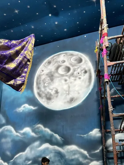 A close-up of the hand-painted moon. Creating a realistic texture on such a large scale requires specific techniques. This became the central focus of the backdrop for the celestial-themed Ganpati decoration.
