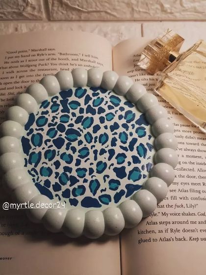 Another shot of our hand-painted blue leopard print bubble tray, styled with a bottle of perfume.