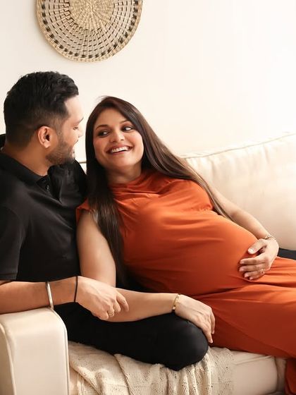 Laughter and love fill the frame in this candid shot. Relaxing on the couch, this couple shares a natural, happy moment that truly reflects their personalities.