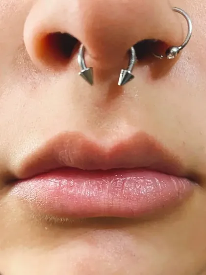 A close-up of a well-placed septum piercing, also known as a bull ring. I check your anatomy carefully to ensure the piercing is centered and sits correctly for maximum comfort.
