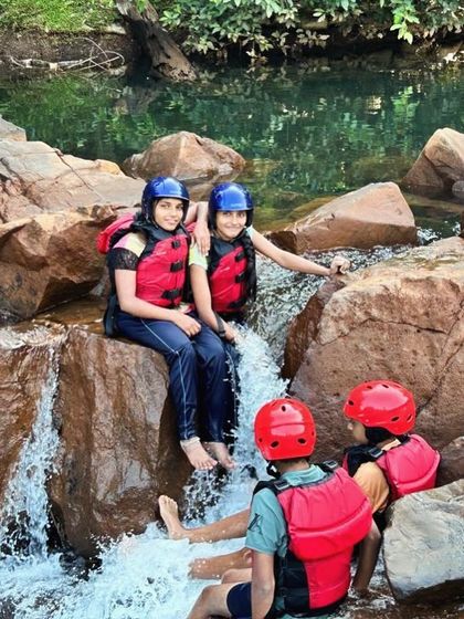 A group of campers finds a perfect spot to sit and enjoy the natural water flow in Dandeli.