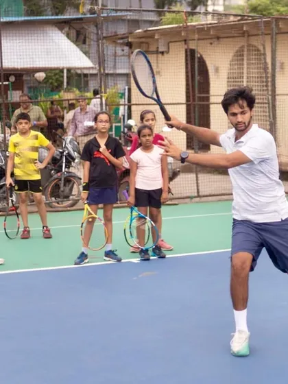Leading by example is a core part of my coaching. Here, I'm demonstrating the correct forehand technique and contact point to a group of our young players, ensuring they see and understand the form we're working towards.