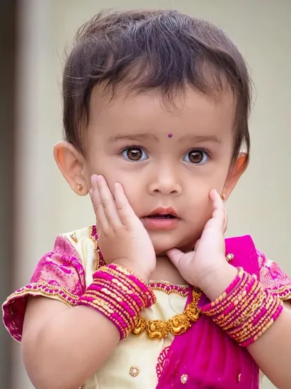Such an adorable face! This little client is wearing a traditional cream and pink silk pavadai set. The simplicity of the design really lets her sweet personality shine through.