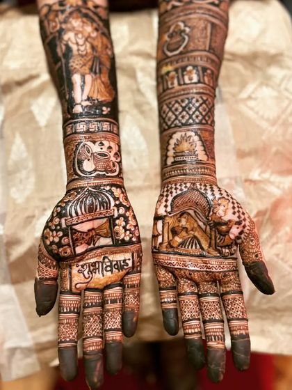 This bridal mehendi is rich with symbolism, featuring a Shiv-Parvati portrait, a bride in a doli, and the auspicious wedding chant 'Shubh Vivah' written on the palm.