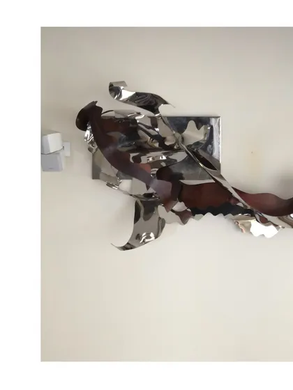 A 12-foot long abstract art installation from 2017, made of flowing, ribbon-like forms of stainless steel.