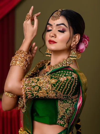 A side view of the bridal look, highlighting the intricate details of the blouse embroidery and jewelry.