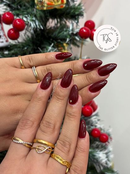 A classic deep red manicure perfect for the holidays. The almond shape keeps it modern, and a single tiny rhinestone on the accent nail adds a subtle hint of sparkle.
