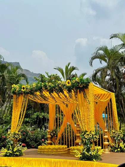 For this outdoor Haldi ceremony, we built a stunning mandap drenched in vibrant yellow. The structure is heavily decorated with marigold garlands and fresh sunflowers, creating a traditional and cheerful atmosphere against a beautiful natural backdrop.