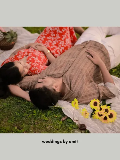 A relaxed and intimate shot of a couple lying on a picnic blanket, sharing a quiet moment together. This is what capturing real 'pyar' looks like.