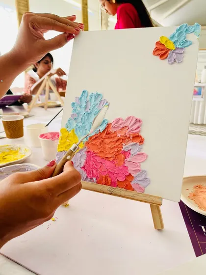 Applying colorful texture paste to create a floral design. The process is like sculpting with paint.