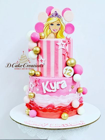 A trendy two-tier Barbie cake for Kyra's 12th birthday. The design features shades of pink, gold accents, and a stylish Barbie illustration.