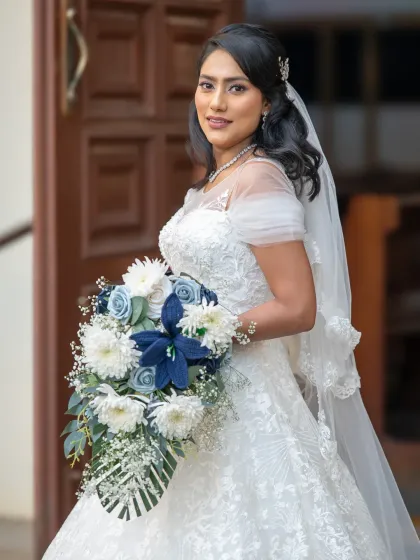 A beautiful close-up of the bride, showcasing her stunning bouquet and intricate dress details. A classic portrait for any wedding album.