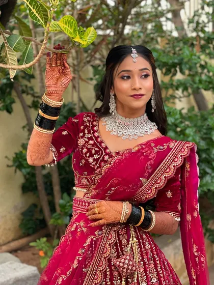 The complete look, with the bride posing elegantly in her red velvet lehenga.