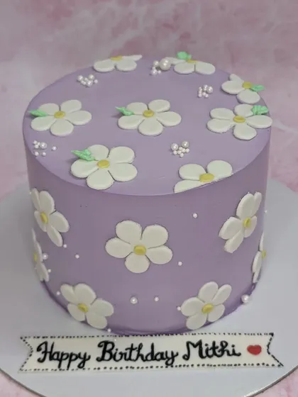 A lovely lilac cake with daisy flowers. This tall chocolate cake has a simple yet elegant design, perfect for Mitthi's birthday.