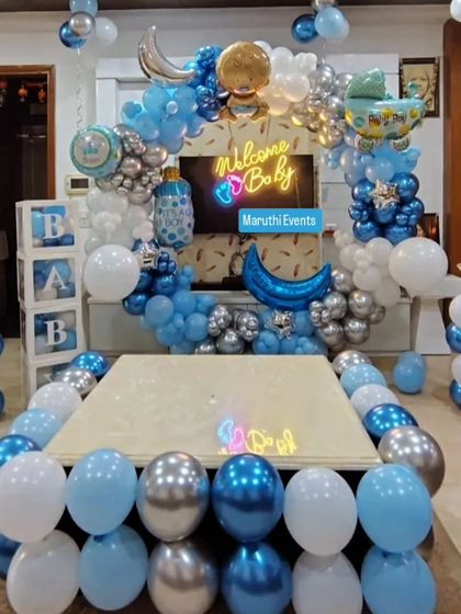 A grand 'Welcome Baby' decoration in blue and silver. This setup fills the room with a balloon arch, 'BABY' blocks, and themed foil balloons around a central table.