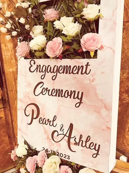 The full view of the engagement welcome sign, showcasing its clean lines and beautiful floral accents. We ensure every detail, from the font to the flower choice, aligns with the couple's vision.