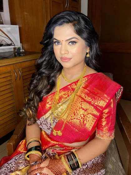 A beautiful South Indian engagement look. The makeup is kept classic and clean to complement the vibrant red silk saree and traditional gold jewelry.