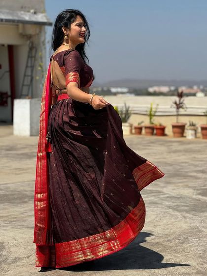 A side view of the maroon half-saree, showing the open-back design of the blouse.