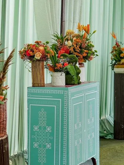 A closer view of the entrance decor, highlighting the hand-painted turquoise console and the mix of rustic and ceramic vases.