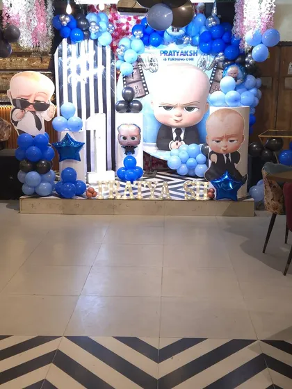 This is how I bring popular themes to life. Here's a look at a 'Boss Baby' first birthday party setup at my Noida Sector 63 hall, featuring a custom backdrop, character cutouts, and a blue and black balloon arrangement to create the perfect photo zone.
