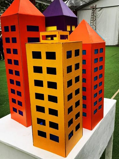 These colorful cardboard skyscrapers were created as part of a superhero city theme. They are lightweight, eco-friendly, and can be arranged to create a dynamic city skyline for an entrance or a photo booth backdrop.