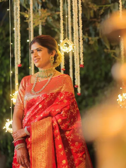 The bride stands under a canopy of lights, her makeup glowing. This look is a perfect example of subtle yet impactful reception glam.