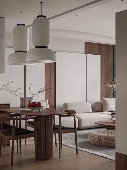 This angle shows the connection between the dining area and the kitchen, emphasizing the open-plan flow. The consistent use of natural wood and neutral tones ensures a cohesive transition between the different functional zones.
