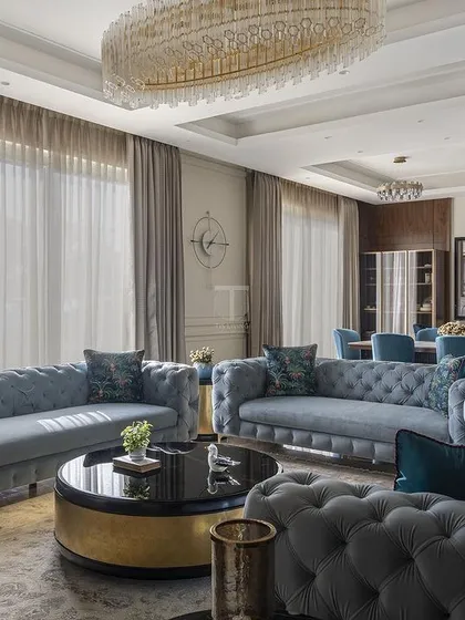 A beautiful example of a formal living room we furnished. The classic tufted sofas in a soft blue fabric, paired with a statement coffee table, create an atmosphere of timeless elegance and sophisticated comfort.