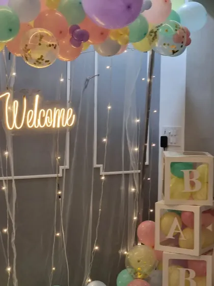A close-up view of the "Welcome" neon sign and 'BABY' blocks from the pastel setup.