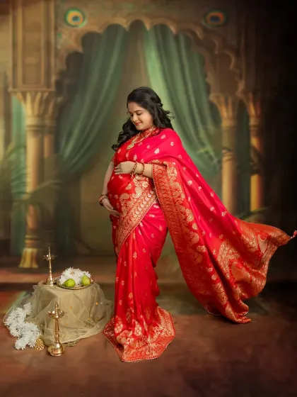 The flowing red saree creates a sense of movement and grace in this stunning solo portrait. It’s a celebration of your strength and beauty during pregnancy.