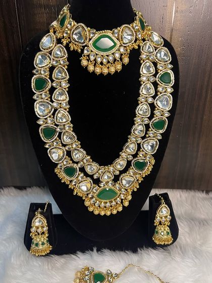 Our popular green and white Kundan bridal set, displayed to show all its components. This rental includes a choker, a two-layer long necklace, a pair of jhumka earrings, and a maang tikka. It's a complete and affordable solution for your wedding jewellery.