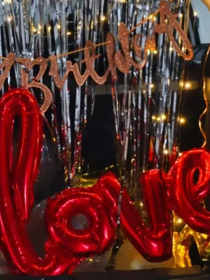 A detailed shot of the 'LOVE' foil balloon in the car boot setup. These small details make a big difference in creating a memorable surprise.