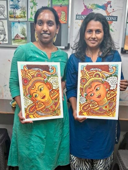 Two happy students holding up their finished Kerala mural paintings. It is wonderful to see their unique interpretations of the same subject, each a masterpiece in its own right.