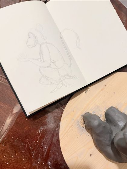 The very beginning of the process. Every sculpture starts with a sketch. Here is my initial drawing in my sketchbook next to the first pieces of clay being shaped.
