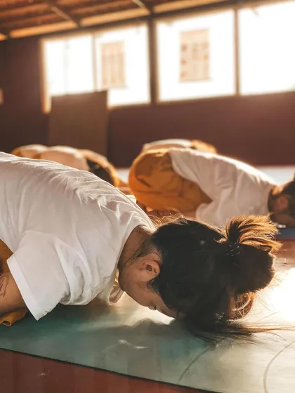 This is a duplicate of image 69. A close-up on students in Child's Pose, emphasizing the importance of surrender and rest in a balanced yoga practice.