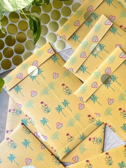 A stack of the sealed yellow floral envelopes. The simple sticker seal is a neat and effective way to close these beautiful, custom-printed envelopes.