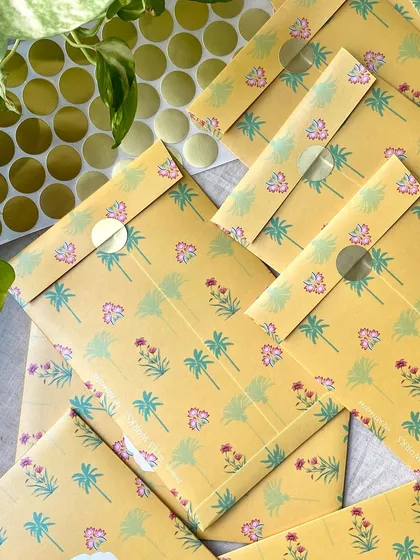 A stack of the sealed yellow floral envelopes. The simple sticker seal is a neat and effective way to close these beautiful, custom-printed envelopes.