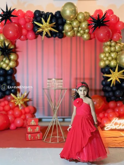 A bold and chic party theme using a dramatic red, black, and gold color palette with star-shaped balloons for a glamorous look.