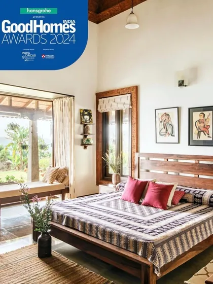 This bedroom in the Varadarajan House opens directly to the garden through a large window and seating nook. The design uses natural materials like wood and stone, with simple furnishings and handcrafted textiles, to create a restful space that is connected to the outdoors.