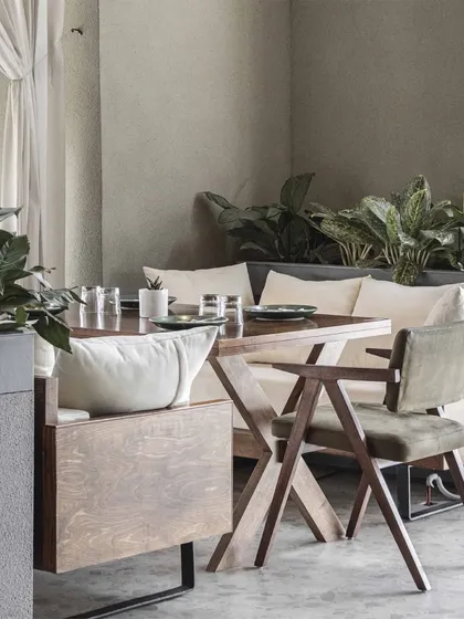 We curated a careful balance of textures, shapes, and materials to make the space visually captivating. Here, the smooth concrete floor contrasts with the warm wood of the furniture and the soft upholstery.