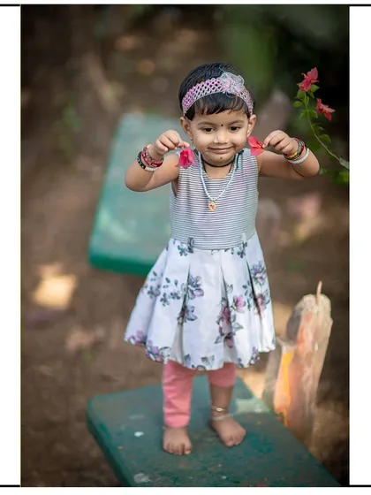 A proud smile as she shows off the flowers she picked. Outdoor sessions are full of these small, unscripted discoveries.