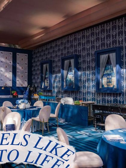 The interior of the teddy bear-themed party, showing the custom blue patterned wallpaper and matching tablecloths. Every element is designed to immerse guests in the theme.
